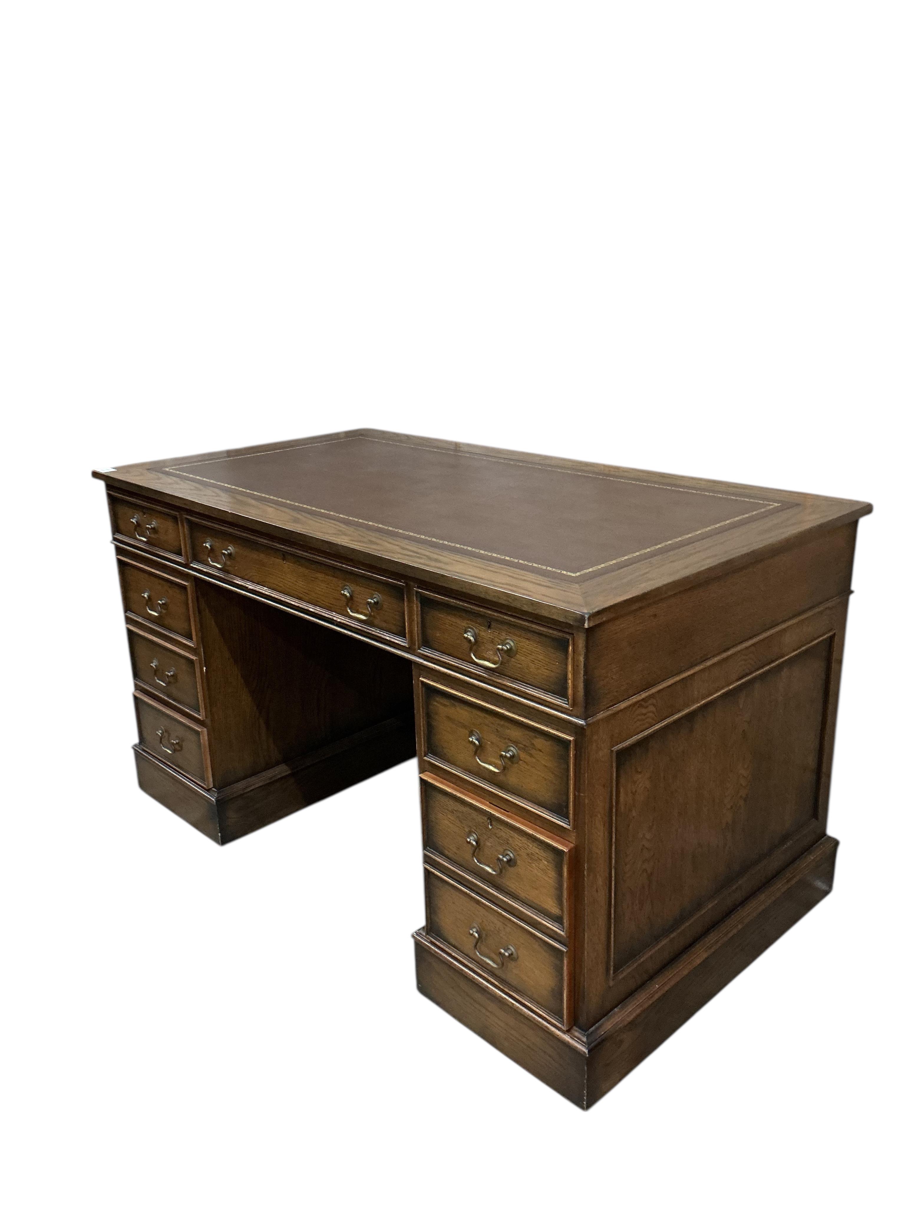 A reproduction oak pedestal desk, width 137cm, depth 76cm, height 78cm